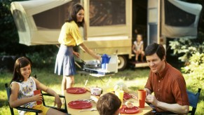 A family smiles outside of their pop-up camper