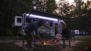 Christian Arriola and Washington Post travel writer Andrea Sachs sit around a fire outside of their rented RV