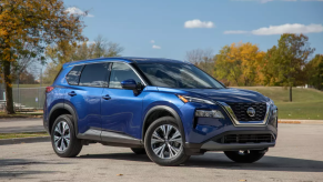 A blue 2021 Nissan Rogue parked on the track.