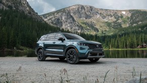 a Kia Sorento X-line parked by a lake in the mountains