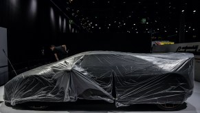 A Lamborghini is hidden under a cover on the grounds of the fair