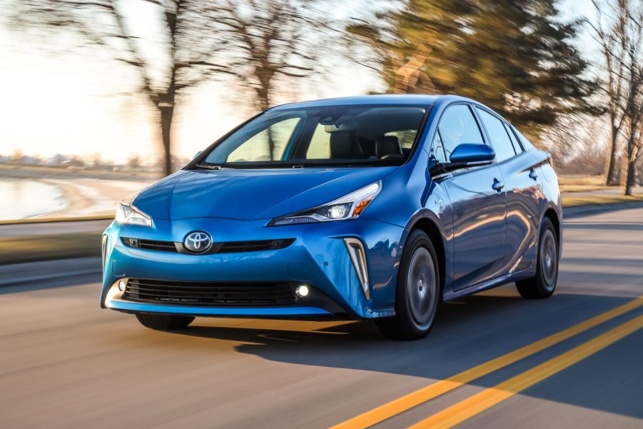 blue Toyota Prius at speed on a lakeside road