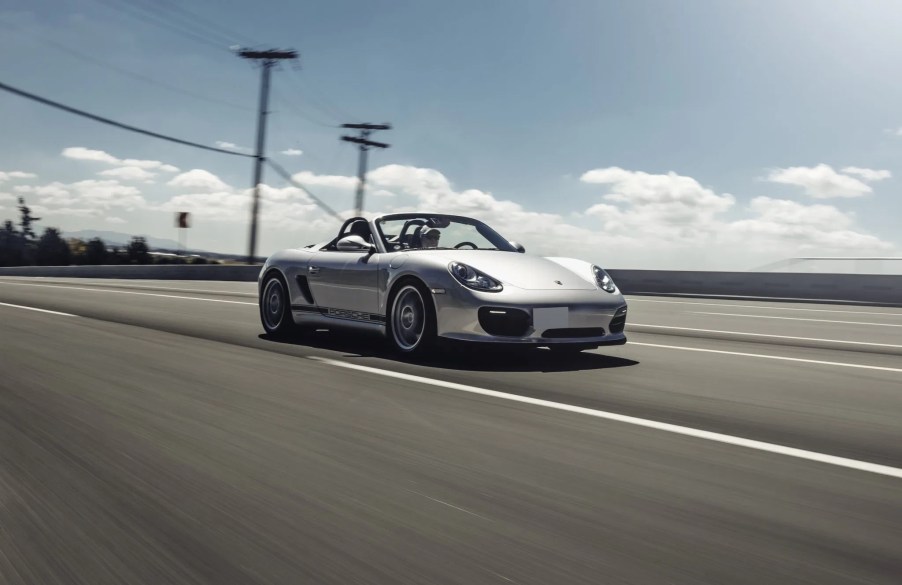 A silver 2011 Porsche Boxster Spyder drives down the road