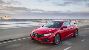 red 2017 Honda Civic sedan driving on highway bridge