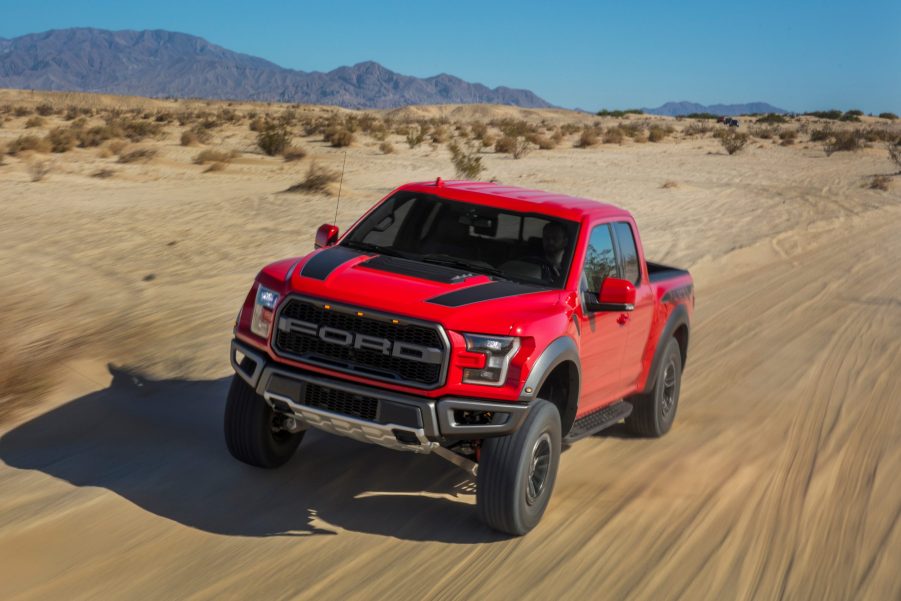 A red 2020 Ford Raptor runs through the desert.