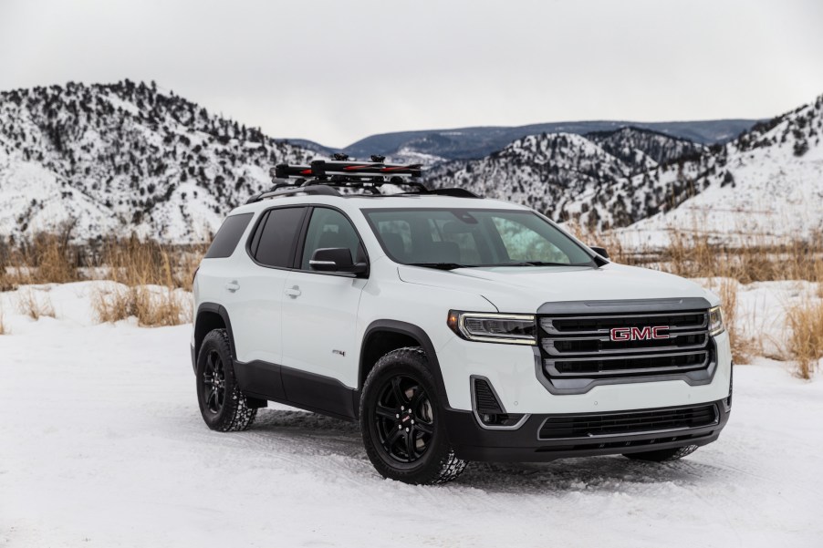 A white 2020 GMC Acadia AT4 is parked in the snow.