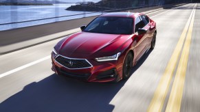 A red 2021 Acura TLX driving down a highway