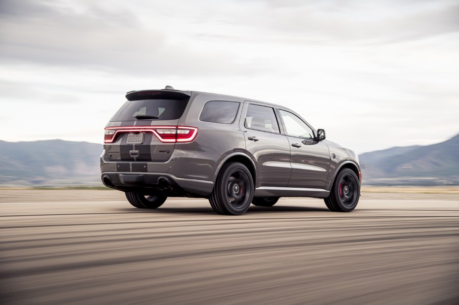 A silver and black 2021 Dodge Durango SRT Hellcat driving away from the camera on a dirt road