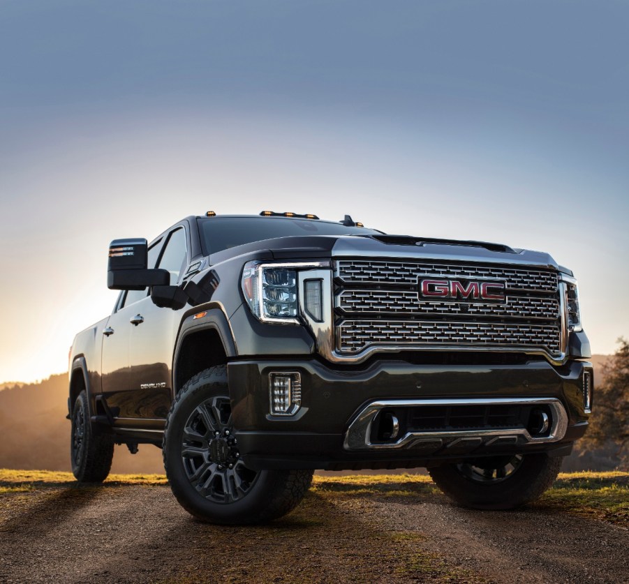 A 2021 GMC Sierra on blacktop with sunset behind it