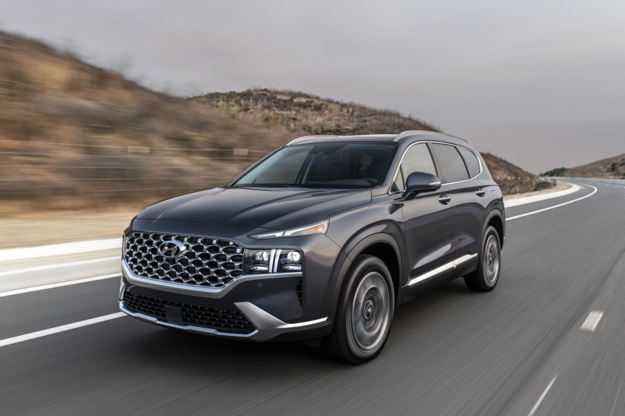 A black 2021 Hyundai Santa Fe driving on a highway road