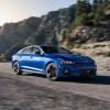 A blue 2021 Kia K5 driving on a highway