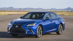 A blue 2021 Lexus ES on display with a mountain range in the background