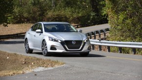 A silver 2021 Nissan Altima driving down a twisty road