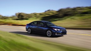 A blue 2021 Subaru Impreza driving down a road