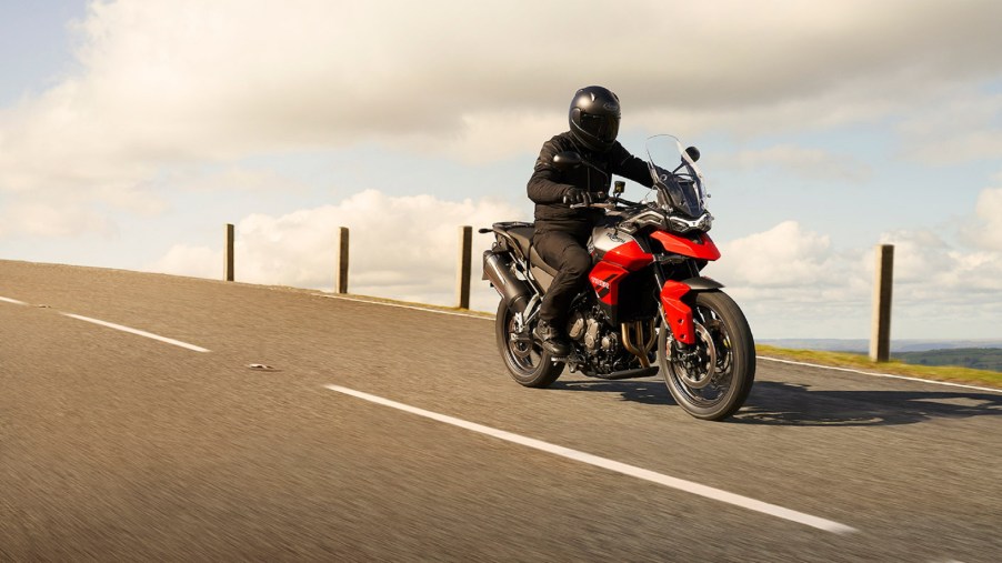 A rider on a red 2021 Triumph Tiger 850 Sport