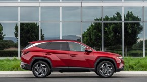 A red 2022 Hyundai Tucson parked in front a building with glass windows