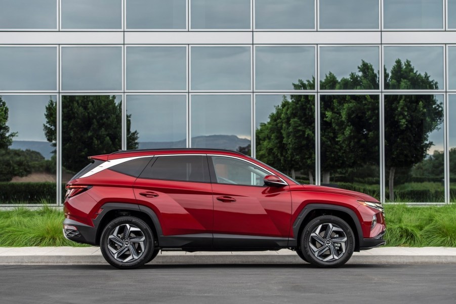 A red 2022 Hyundai Tucson parked in front a building with glass windows