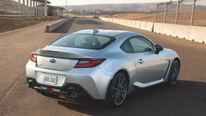 The rear 3/4 view of a silver 2022 Subaru BRZ on a racetrack