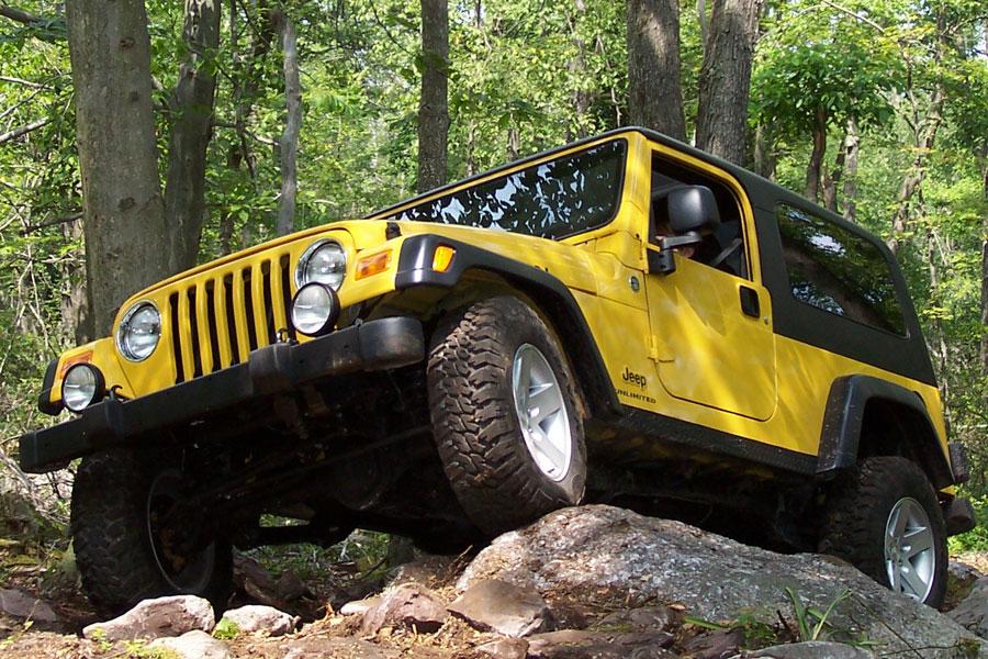 a yellow 2006 wrangler going off-road in the forest