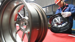 A worker inspects aluminum alloy wheel hubs at an aluminum company