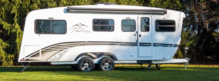 A white 2021 Terra Oasis travel trailer RV is parked on grass.