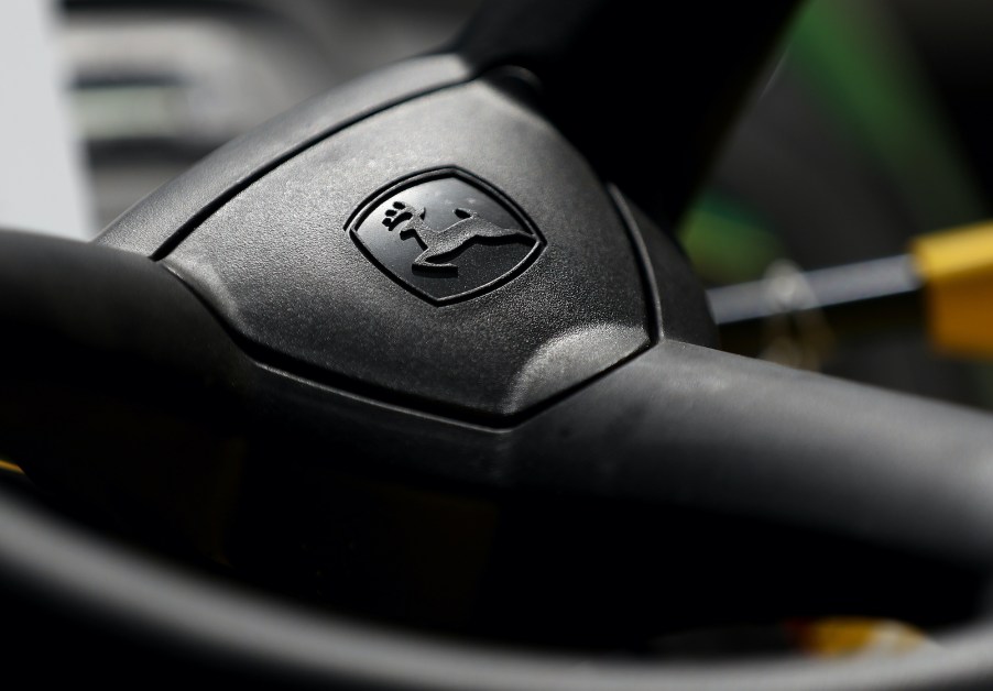 The John Deere logo is seen on a riding mower steering wheel