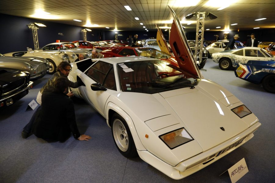 A white Lamborghini Countach is on display at an indoor show.