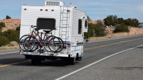 A tourist in an RV with bicycle racks approaches the small town of Chimayo, New Mexico