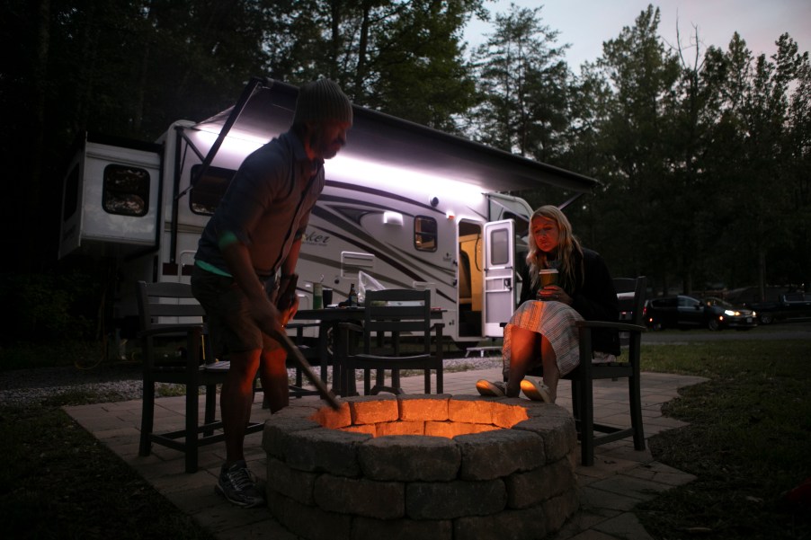 Christian Arriola and Washington Post travel writer Andrea Sachs sit around a fire outside of their rented RV Saturday, September 19, 2020 at a KOA campground