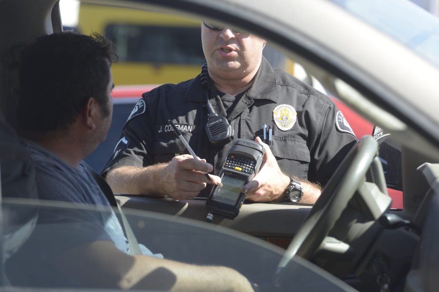 La Habra police officer Jason Coleman issues a speeding citation using a e-citation machine on Monday.