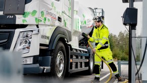 A worker plugs in a Heavy-Duty Electric Volvo Truck.