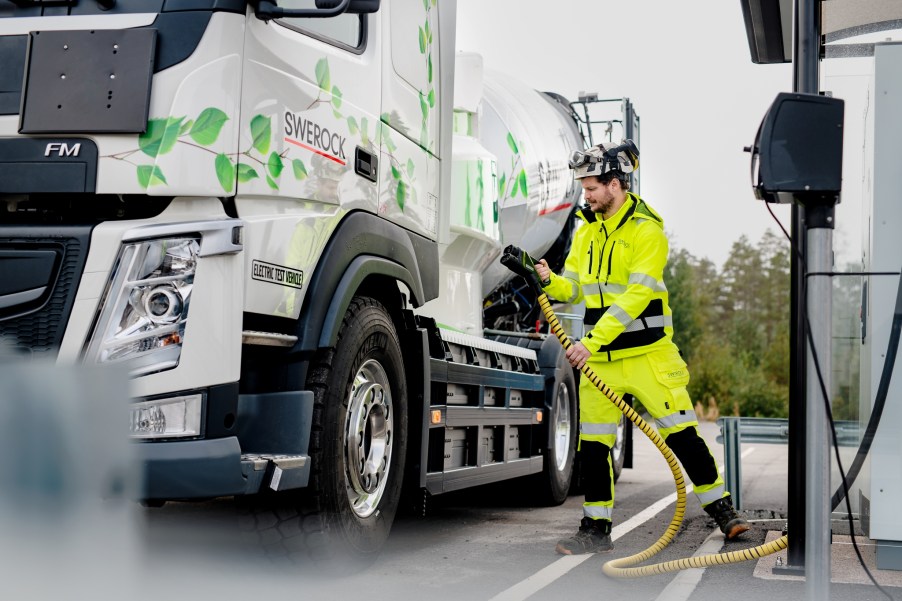 A worker plugs in a Heavy-Duty Electric Volvo Truck.