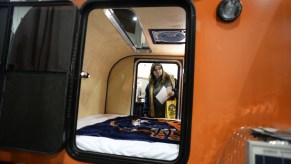 A woman checks out a teardrop camper at an RV show