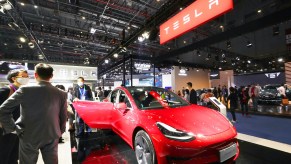 People check out a Tesla Model 3 at the third China International Import Expo