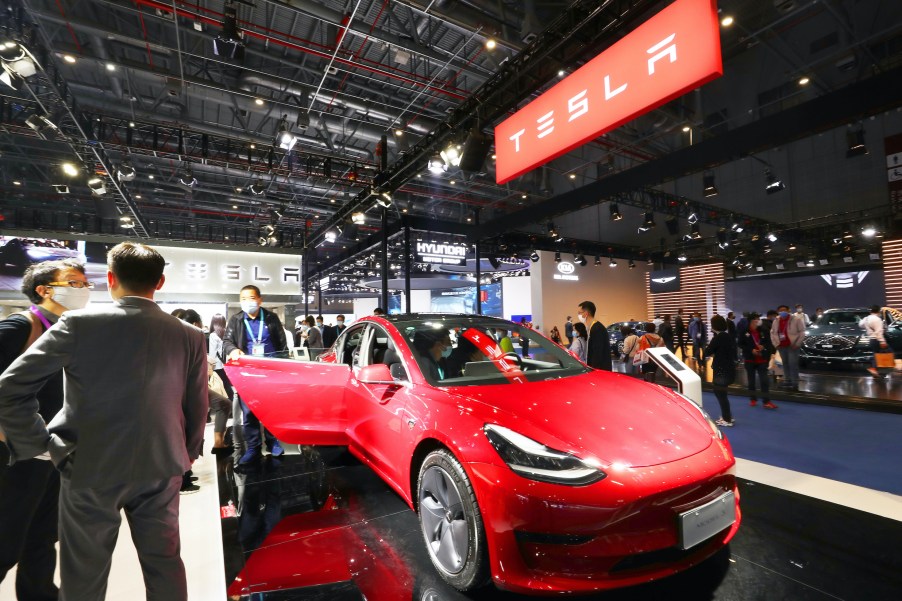 People check out a Tesla Model 3 at the third China International Import Expo