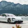 A photo of the Porsche Taycan outdoors by a lake.