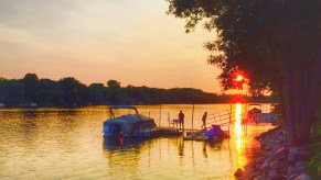 Couple walking on a dock next to a docked pontoon boat on the Mississippi River MN in July 2015.