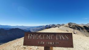 the highest elevation point sign with a mountain view in the background of this pretty off-road trail