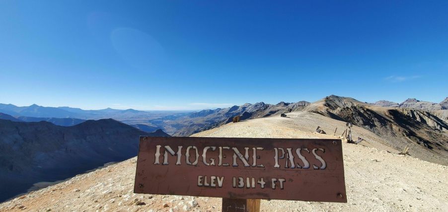 the highest elevation point sign with a mountain view in the background of this pretty off-road trail