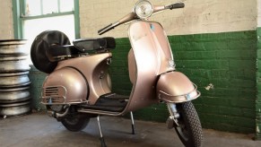 A gold 1965 Vespa VBB 150 scooter on its stand