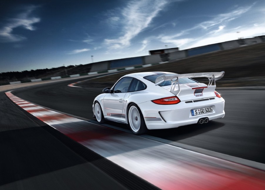 The rear 3/4 view of a white 2012 Porsche 911 GT3 RS 4.0 on a track