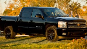 A black 2013 Chevy Silverado is parked on grass in Santa Ana, California.