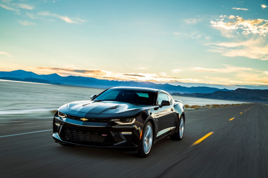 A dark-colored 2016 Chevrolet Camaro drives on a paved road outside Salt Lake City, Utah.