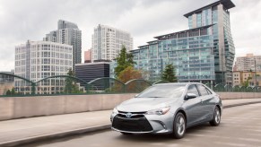 A silver 2017 Toyota Camry Hybrid driving down a highway