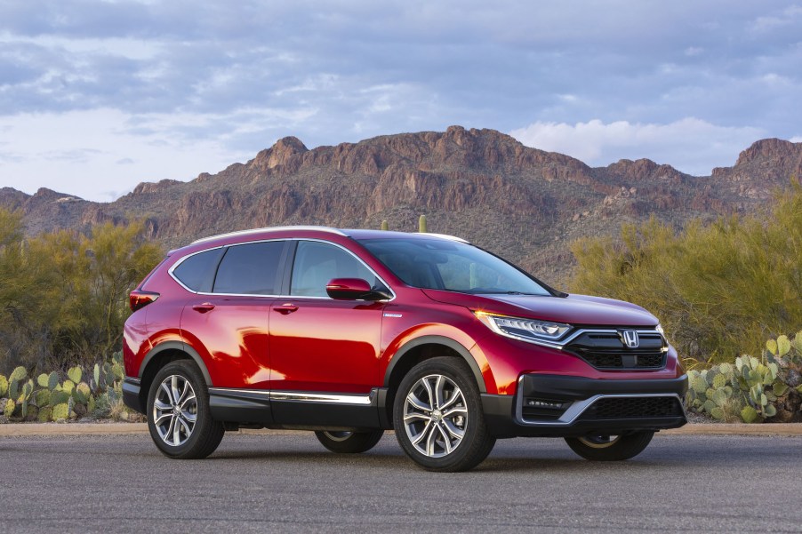 A red 2020 Honda CR-V Hybrid on the countryside.