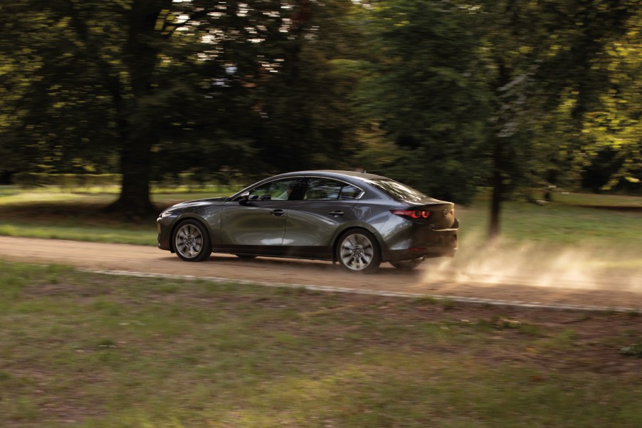 A grey 2020 Mazda3 driving down a dirt road