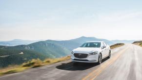 A white 2020 Mazda6 driving down a highway road