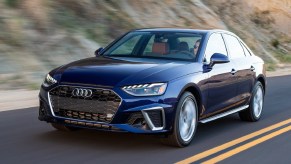 A blue 2021 Audi A4 drives on a road