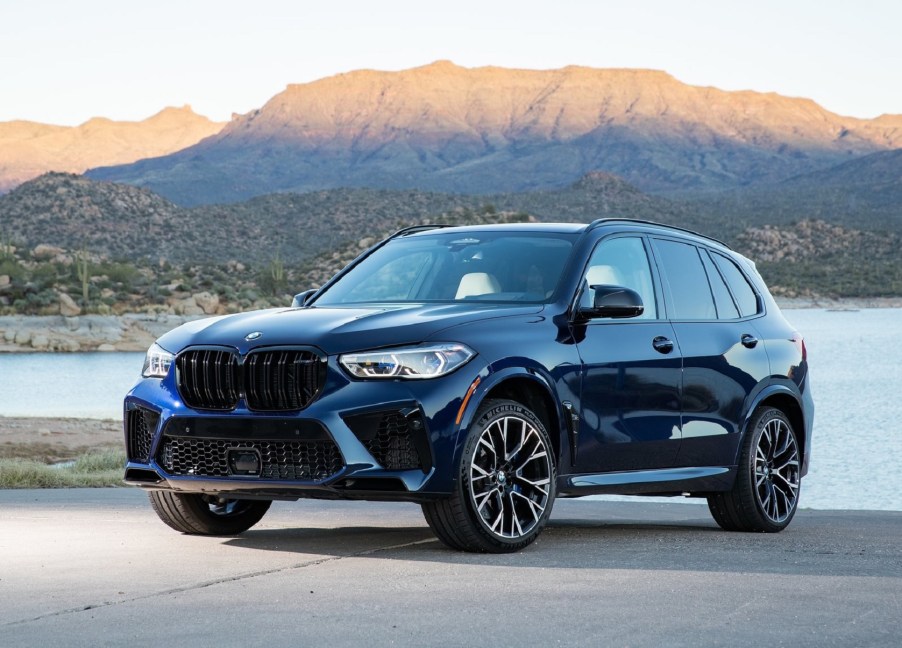 A blue 2021 BMW X5 M Competition by a desert lake