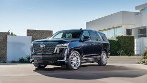 A black 2021 Cadillac Escalade is parked outside a modern home